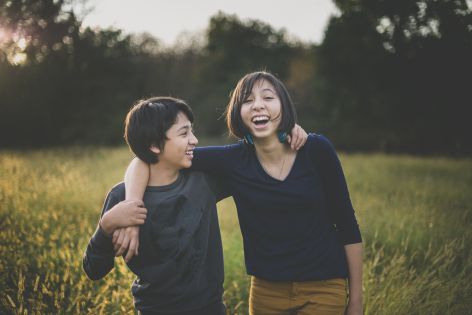 Séance famille en extérieur - frère et soeur rigolent - Photographe famille